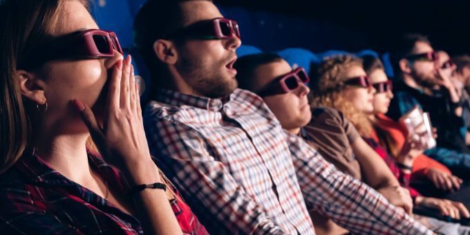 Movie goers gasping in shock as something exciting happens on the screen